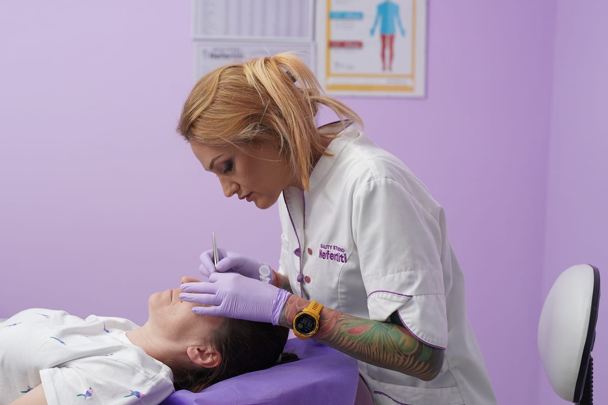 Специалист на Beauty Studio Nefertiti се грижи за кожата на лицето на клиентка след процедура